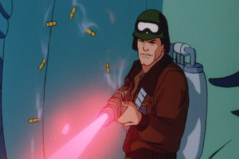 A G.I. Joe character fires a gun towards the camera (at something offscreen). He is dressed like a soldier, the gun looks like a real gun, and shells are coming out of the gun. But the blast from the gun is laser beam (like from Star Wars or Star Trek).