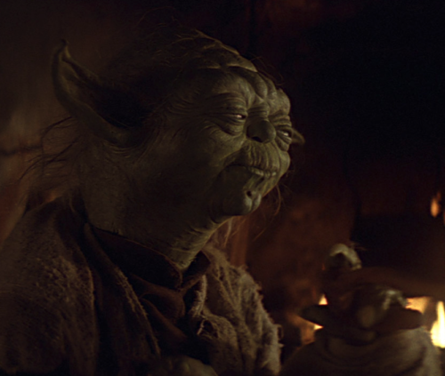 Master Yoda, as seen in "The Empire Strikes Back" (1980). He is indoors, and looking away to the right with a skeptical gaze.